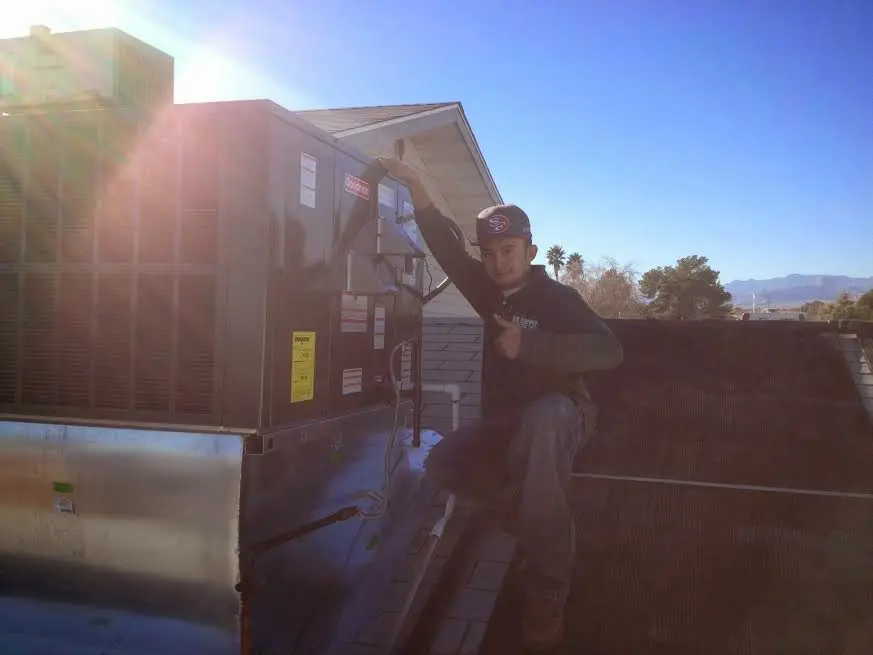 HVAC technician performing AC Tune-Up on a rooftop unit in Marshall